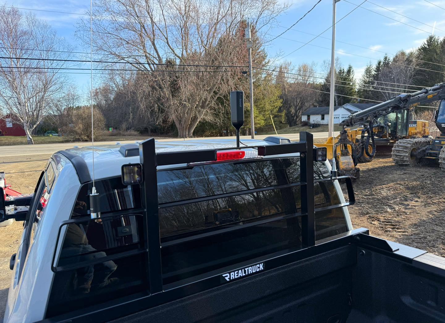 Cell booster and dual antennas mounted on a truck headache rack in an equipment yard